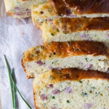 sliced savoury bread with pieces of ham and herbs.