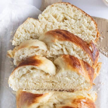 sliced french braided brioche on a wooden board.