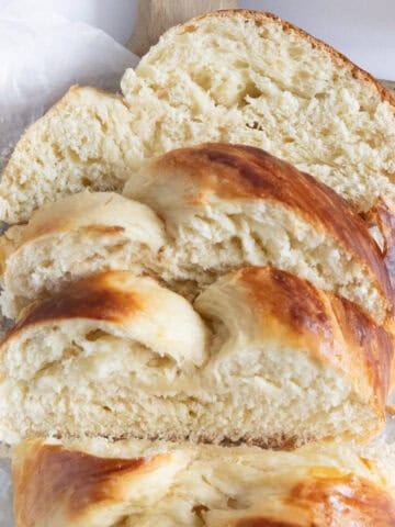 sliced french braided brioche on a wooden board.