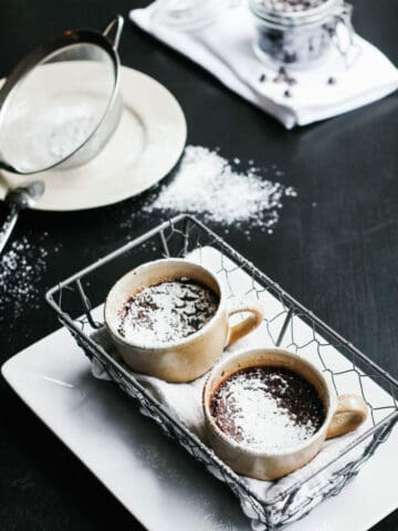 Cup filled with chocolate pot de creme and spoon picking some.