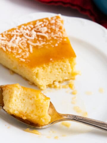 a slice of flan with a spoon and some flan in the spoon.