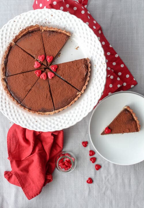View from above of a sliced dark French chocolate tart on a shortbread crust.