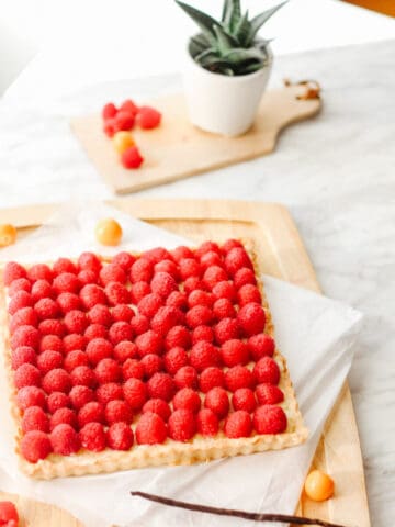 Side view of a raspberry tart with french vanilla pastry cream filling