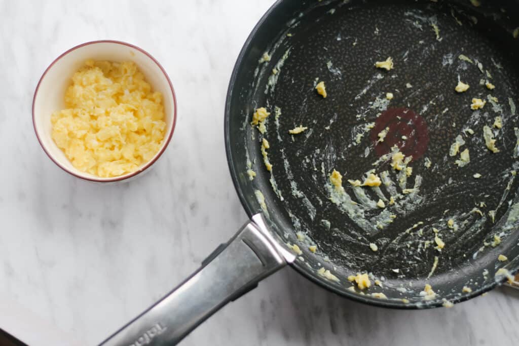 Eggs cooked in a bowl and pan on the side