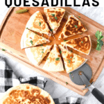 Breakfast quesadillas, one sliced in 8 on a wooden board and another whole