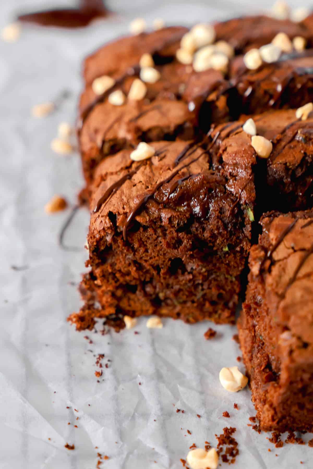 sliced square chocolate zucchini cake on a parchment paper. 