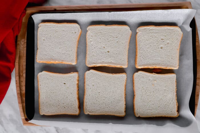 Bread slices on a baking sheet.