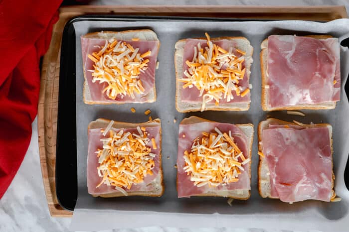 Top view of cheese on ham and bread on a baking sheet
