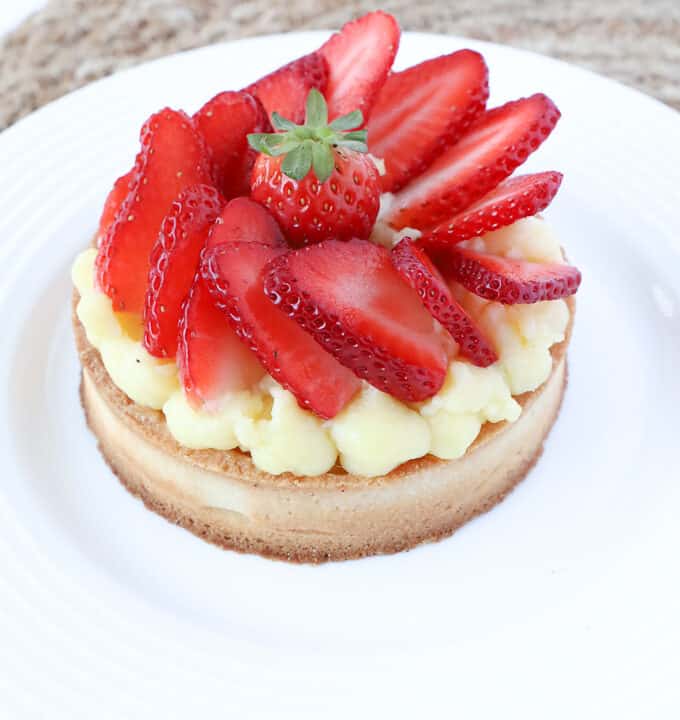 Individual serving of a strawberry pie in a white plate.