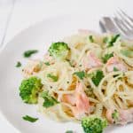 Close up of salmon and broccoli pasta in a white plate