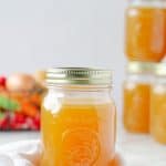Close up of a Mason jar with broth in it and a few jars in the background