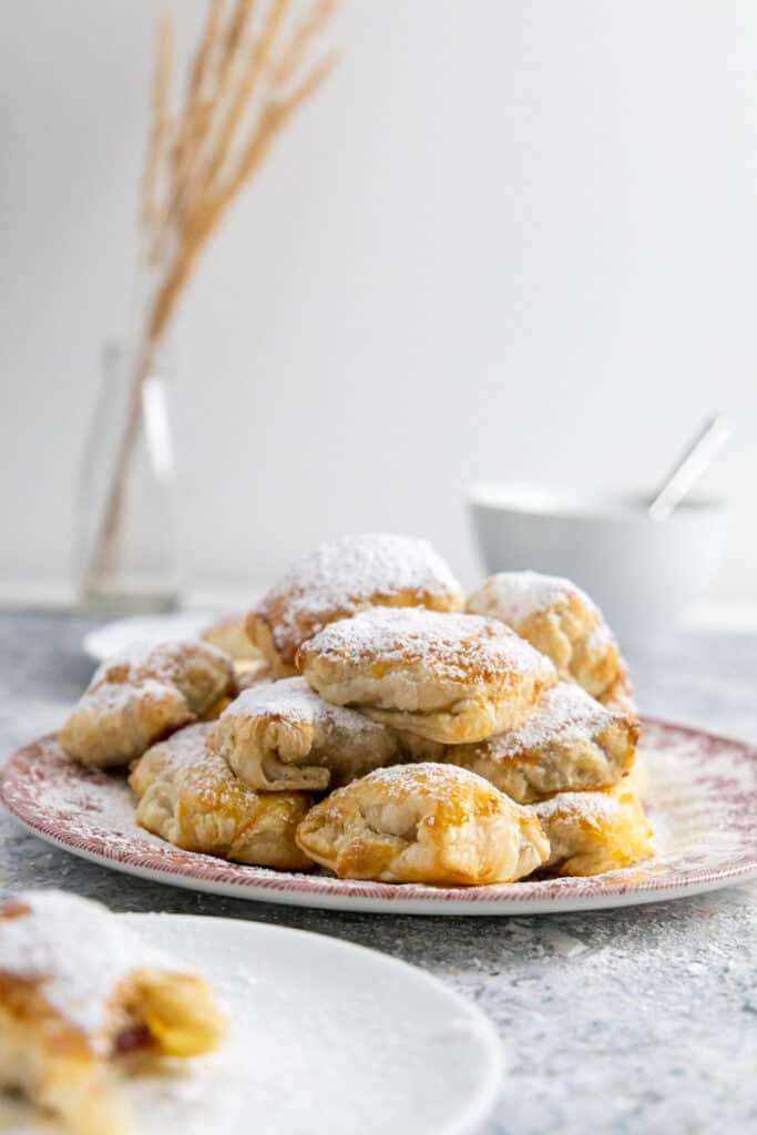Side view of a pile of pastelitos de guayaba on a pink plate