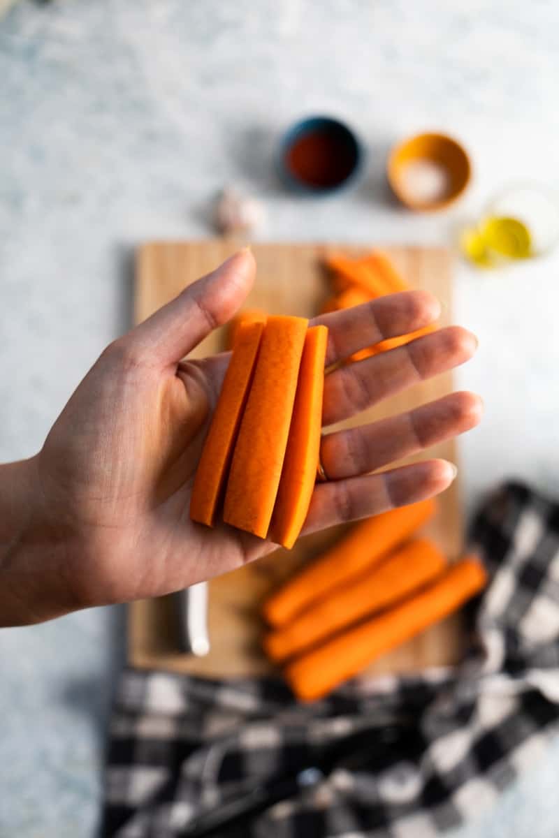 close up on a hand holding carrot sticks