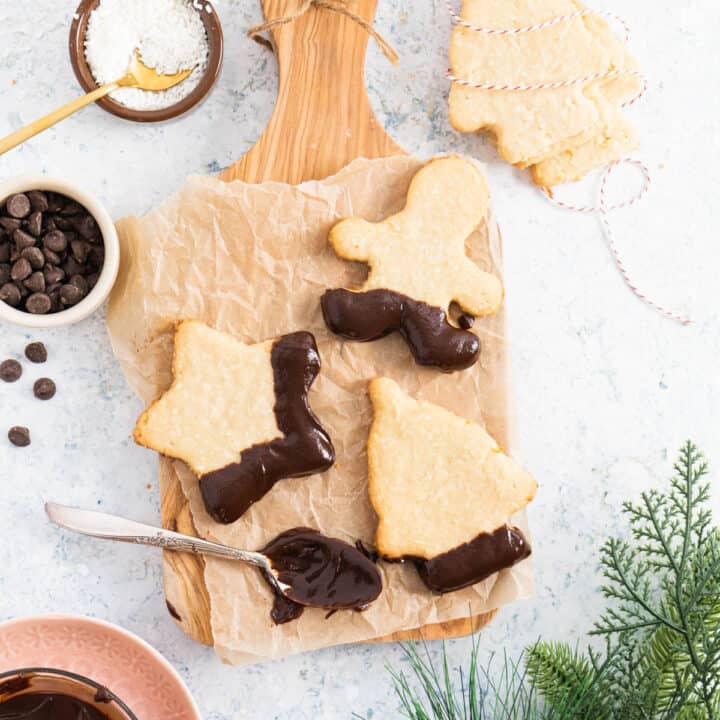 cookies on a wooden board with chocolate chips on the side and sugar.