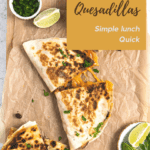 top view of some quesadillas on a brown paper. The quesadilla is sliced and the cheese is pulled. there is some cilantro in a small ramekin and slice of lime