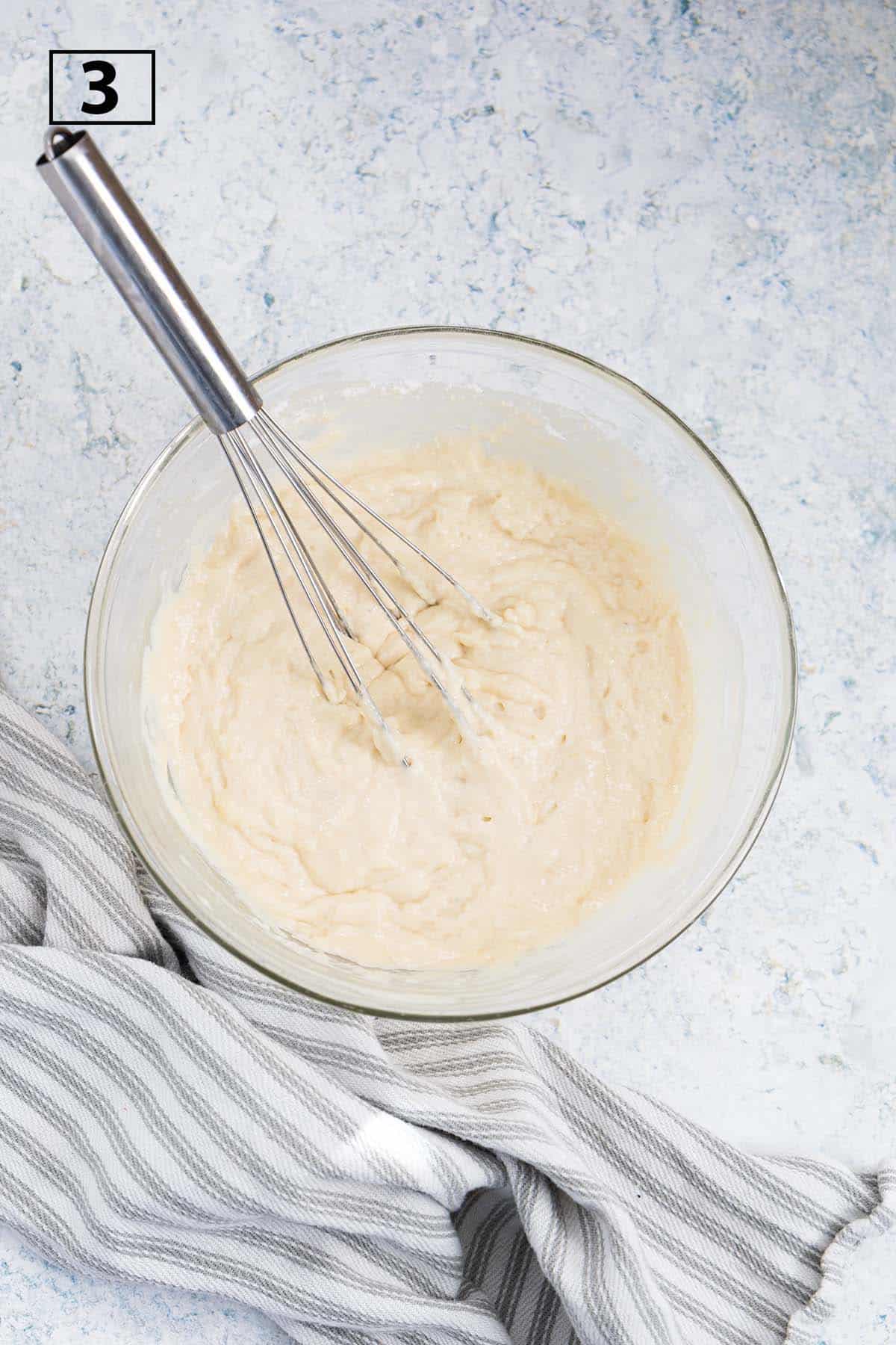 Pancake batter in a mixing bowl with a whisk