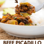 Beef picadillo on a fork with a sliced olive and some more picadillo in a white plate with white rice.