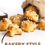 chouquette coming out of a brown paper bag with a brown ramekin full of sugar pearls, a chouquette is bitten.