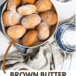 plate full of french madeleines powdered with icing sugar and small blue plates on the side.
