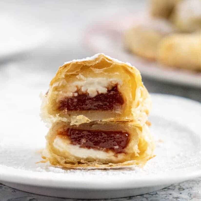 Side view of a sliced pastelitos de guayaba showing the cream cheese and the guava paste